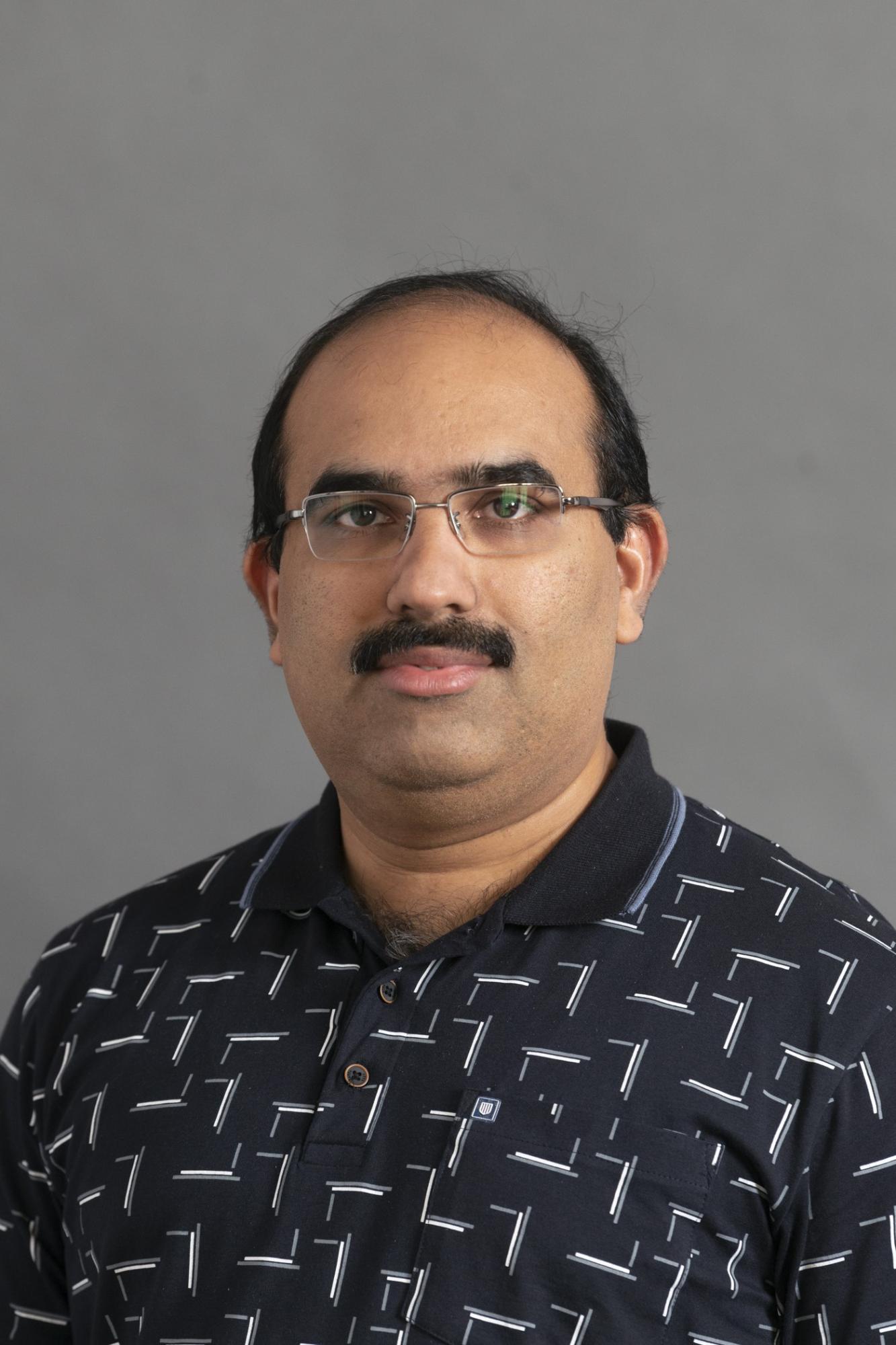 man with dark hair beard and glasses