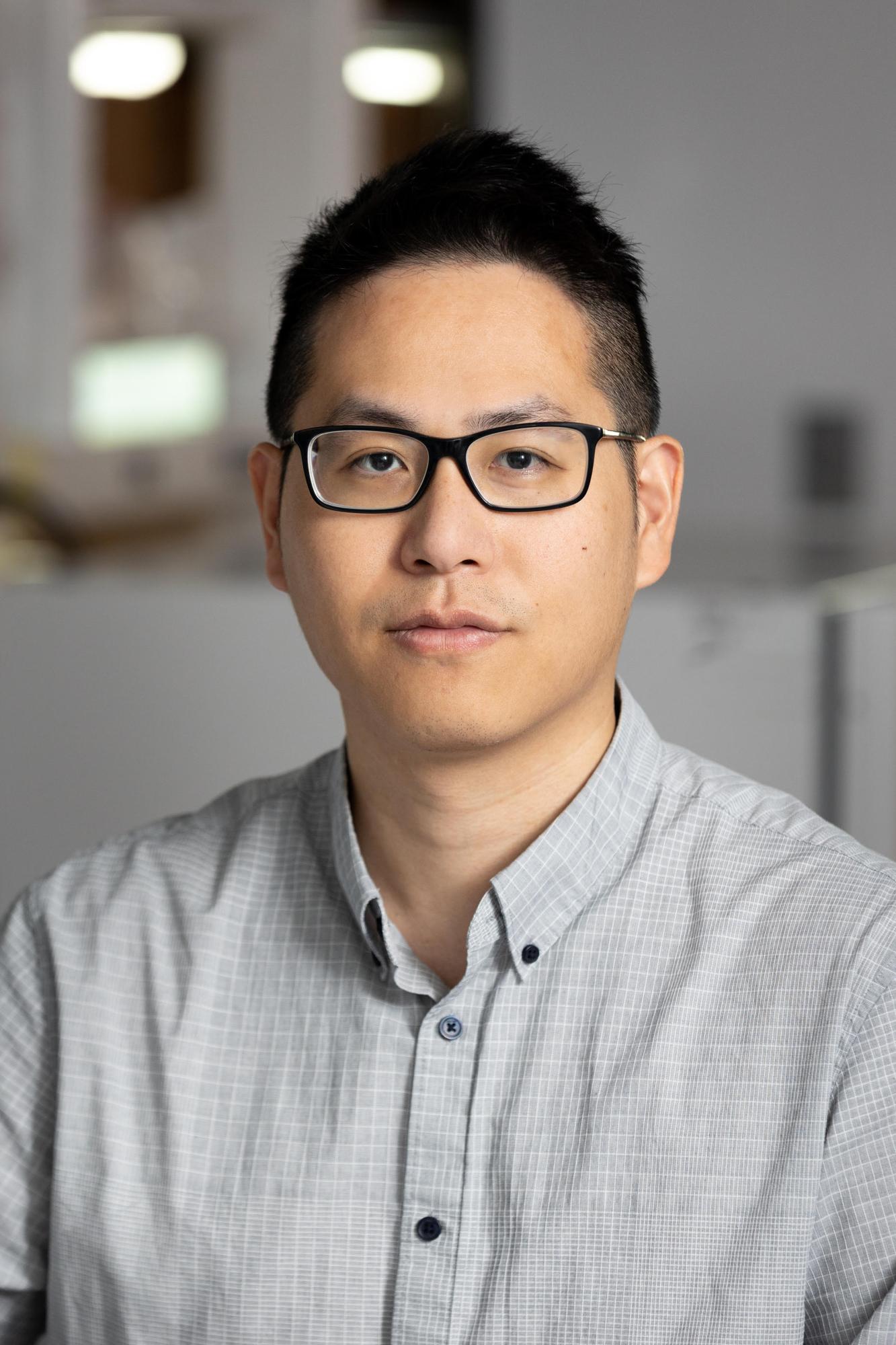 Man with dark hair and glasses